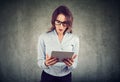 Stunned woman, surprised with wide open mouth, shocked by what she sees on her tablet Royalty Free Stock Photo