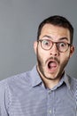 Stunned young bearded businessman with eyeglasses and mouth open