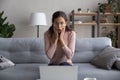 Stunned young woman shocked by news on laptop