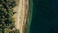 Stunning aerial drone minimal geometric image of a remote tropical sea ocean shore with sandy beach lush rainforest jungle and