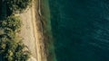 Stunning aerial drone minimal geometric image of a remote tropical sea ocean shore with sandy beach lush rainforest jungle and