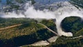 Stunning aerial panorama view of the majestic and powerful Victoria Falls with historic bridge. Royalty Free Stock Photo