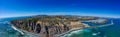 A stunning aerial panoramic shot of the deep blue ocean water and the sandy beach and the boats on the harbor Royalty Free Stock Photo