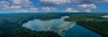 A stunning aerial panoramic shot of the still blue waters of the lake with blue sky and clouds reflecting off the water Royalty Free Stock Photo