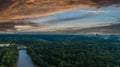 A stunning aerial shot of the Chattahoochee river surrounded by lush green and autumn colored trees with powerful red clouds Royalty Free Stock Photo