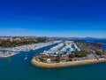 A stunning aerial shot of the deep blue ocean water and the sandy beach and the boats on the harbor Royalty Free Stock Photo