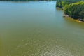 A stunning aerial shot of a rippling green lake surrounded by lush green trees and plants with boat houses along the water Royalty Free Stock Photo