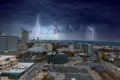 A stunning aerial shot of the skyscrapers and the buildings in the cityscape with powerful clouds and lightning at sunset