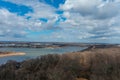 A stunning aerial shot of the vast flowing waters of the Mississippi river with miles of brown and bare winter trees with blue sky