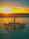 Stunning aerial sunset view of a private beachfront property with a dock reaching out into ocean