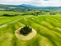 Stunning aerial view of green fields and farmlands with a group of cypress trees in the middle. Summer rural landscape of rolling Royalty Free Stock Photo