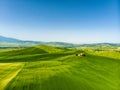Stunning aerial view of green fields and farmlands with small villages on the horizon. Rural landscape of rolling hills, curved