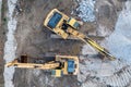 Aerial view of the stopped yellow excavators at a construction site