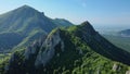 A scenic aerial view of a treecovered mountain under a sunny sky