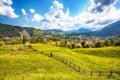 Stunning alpine landscape with green fields and Piatra Craiului mountains in Dambovicioara Commune