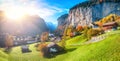 Stunning autumn landscape of alpine village Lauterbrunnen with famous church and Staubbach waterfall