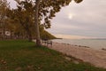 Stunning autumn landscape view of beautiful Lake Balaton during sunset. Plane trees alley is famous touristic place Royalty Free Stock Photo