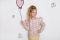 Stunning beautiful little girl with long blond hair standing on a white background and holds a balloon Royalty Free Stock Photo