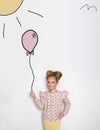 Stunning beautiful little girl with long blond hair standing on a white background and holds a balloon Royalty Free Stock Photo