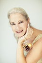 Stunning beautiful and self confident best aged woman with grey hair smiling into camera, holding Christmas decoration baubles Royalty Free Stock Photo