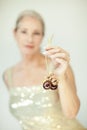 Stunning beautiful and self confident best aged woman with grey hair smiling into camera, holding Christmas decoration baubles Royalty Free Stock Photo