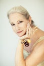 Stunning beautiful and self confident best aged woman with grey hair smiling into camera, holding Christmas decoration baubles Royalty Free Stock Photo