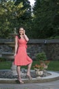 Gorgeous biracial woman poses wearing pink dress in garden