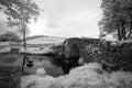 Stunning black and white infrared landscape image of old bridge Royalty Free Stock Photo