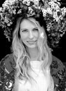 Stunning black and white portrait of a girl on a black background in a huge flower wreath Royalty Free Stock Photo