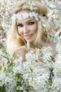 Stunning blonde natural woman swing on a swing on a tree wearing a spring dress Royalty Free Stock Photo