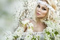 Stunning blonde natural woman swing on a swing on a tree wearing a spring dress Royalty Free Stock Photo