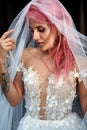 Stunning bride with pink hair covered with light veil