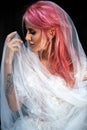 Stunning bride with pink hair covered with light veil