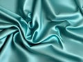 Stunning bright green blue satin silk surface, soft folds on a glossy surface.
