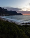 Stunning camps bay with houses on the beach, with dramatic mountains at sunset