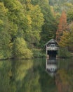 Stunning colorful vibrant Autumn Fall landscape image of boathouse on lake in forest scene