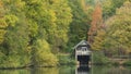 Stunning colorful vibrant Autumn Fall landscape image of boathouse on lake in forest scene