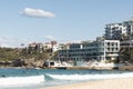 Sydney, NSW/Australia: Bondi Beach with the Iceberg Pool in the background and the surfers