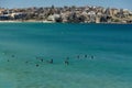 Sydney, NSW/Australia: Bondi Beach with the Iceberg Pool in the background and the surfers