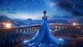 A Beautiful Queen or Princess Wearing a Flowy Sparkling Neon Blue Dress on a High Balcony Looking Down at City Lights Royalty Free Stock Photo
