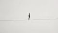 A Man Walking on a Tightrope in a White Background (Balance, Equilibrium, Resilience, Difficult Situation Metaphor) Royalty Free Stock Photo