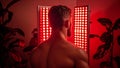 A Fit Man Receiving Infrared Light Therapy Through Radiation Panels, a Type of Powerful Phototherapy Royalty Free Stock Photo