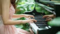A Woman Playing a Traditional Piano Keyboard in a Green Nature Background Royalty Free Stock Photo