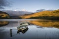 Stunning dramatic stormy sky formations over breathtaking mountain lake landscape with rowing boats in foreground