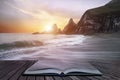 Stunning dramatic sunrise over beach with jagged rocks coastline