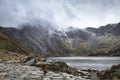 Beautiful moody Winter landscape image of Llyn Idwal and snowcapped Glyders Mountain Range in Snowdonia