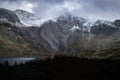 Beautiful moody Winter landscape image of Llyn Idwal and snowcapped Glyders Mountain Range in Snowdonia