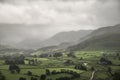 Stunning epic landscape image across Derwentwater valley with falling rain drifting across the mountains causing pokcets of light Royalty Free Stock Photo