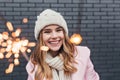 Stunning european girl in knitted accessories enjoying christmas. Outdoor shot of adorable blonde woman holding