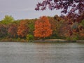 Stunning Fall Scene of Autumn Colored Trees Lining Lake, Bright Blue Sky with Streaking Clouds All Reflected in Calm Water Calm Royalty Free Stock Photo